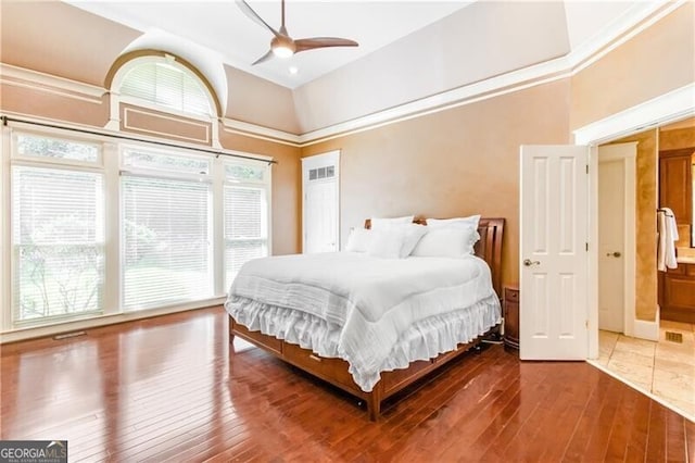 bedroom featuring hardwood / wood-style flooring, ceiling fan, and a towering ceiling