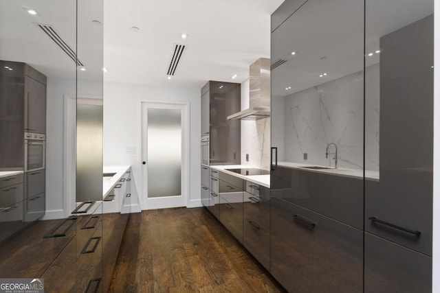 kitchen with dark wood-type flooring, sink, oven, decorative backsplash, and exhaust hood