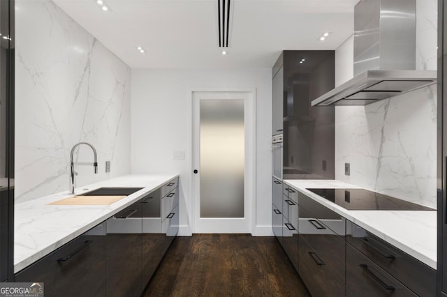 kitchen featuring dark wood-type flooring, sink, light stone counters, ventilation hood, and black electric stovetop