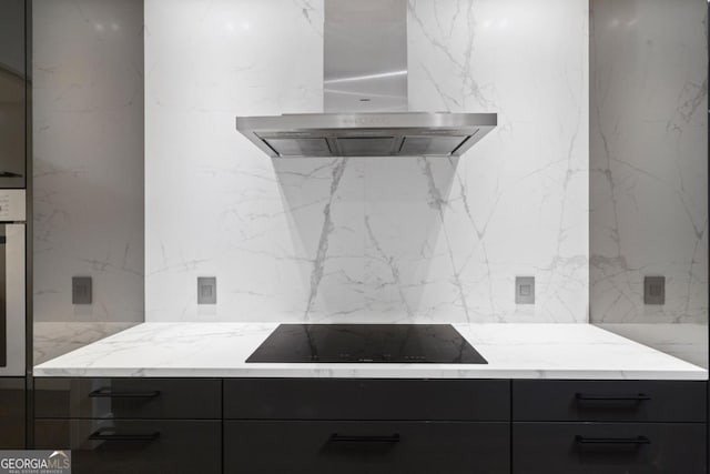 kitchen with black electric cooktop, light stone countertops, and wall chimney exhaust hood