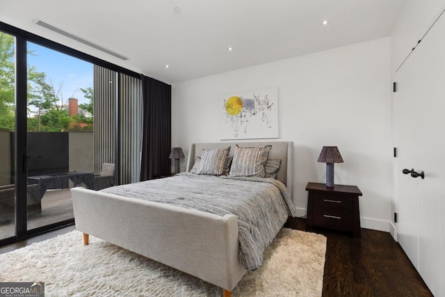 bedroom with floor to ceiling windows and dark hardwood / wood-style floors