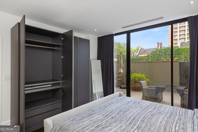 bedroom featuring access to exterior and a wall of windows