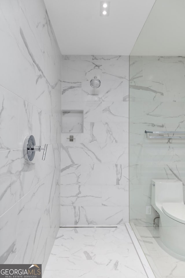 bathroom with tiled shower and toilet