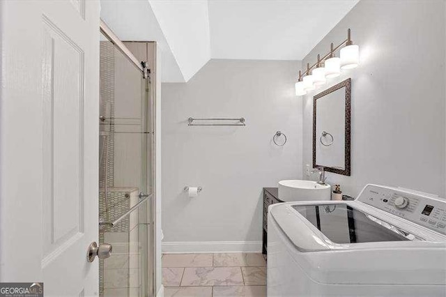 full bathroom featuring marble finish floor, an enclosed shower, washer / dryer, and baseboards