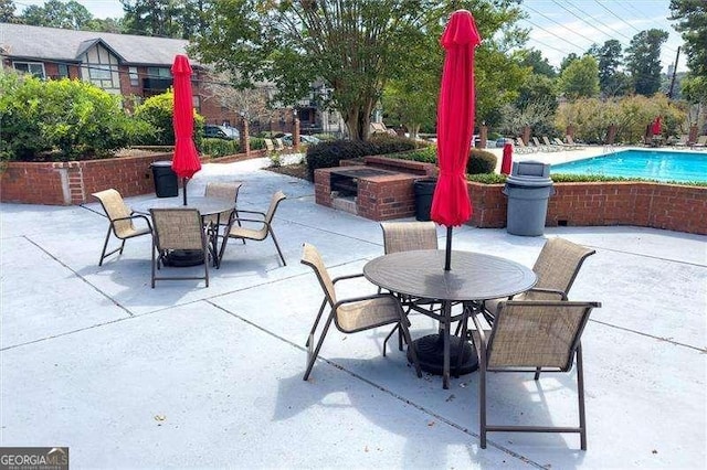 view of patio / terrace with a fire pit, an outdoor pool, and outdoor dining space