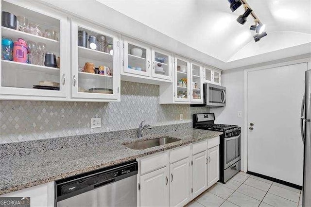 kitchen featuring light stone counters, a sink, white cabinetry, appliances with stainless steel finishes, and decorative backsplash