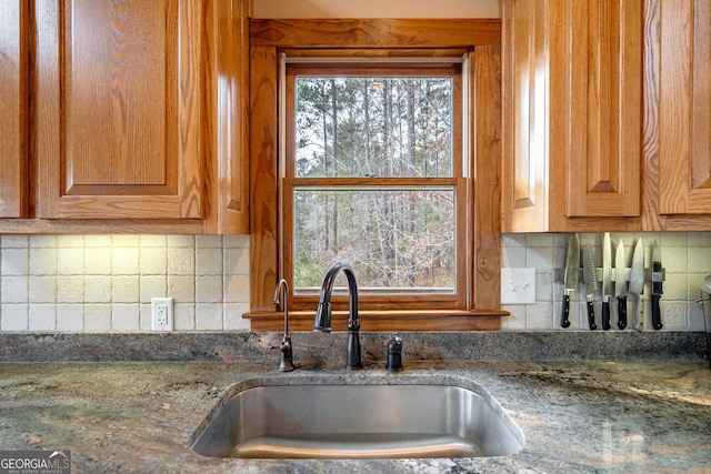 kitchen with stone counters, sink, and decorative backsplash