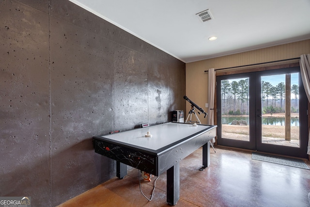 rec room featuring a water view and concrete floors