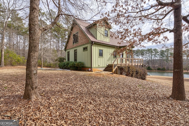 view of side of home with a deck with water view