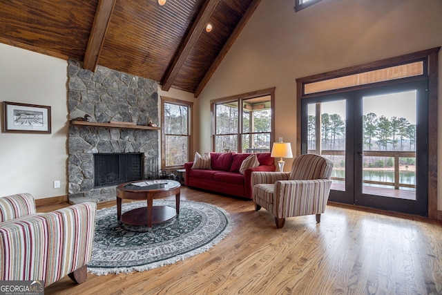 living room featuring hardwood / wood-style floors, beam ceiling, a fireplace, and wooden ceiling