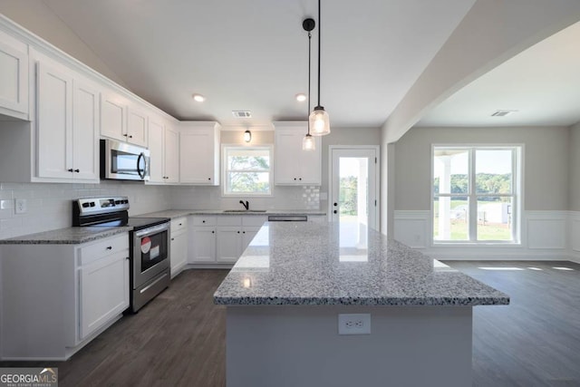 kitchen with white cabinetry, pendant lighting, a kitchen island, and appliances with stainless steel finishes