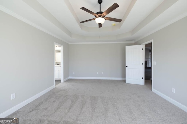 carpeted spare room featuring crown molding, ceiling fan, and a tray ceiling