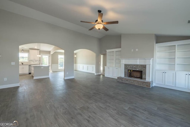 unfurnished living room with dark hardwood / wood-style flooring, lofted ceiling, and ceiling fan