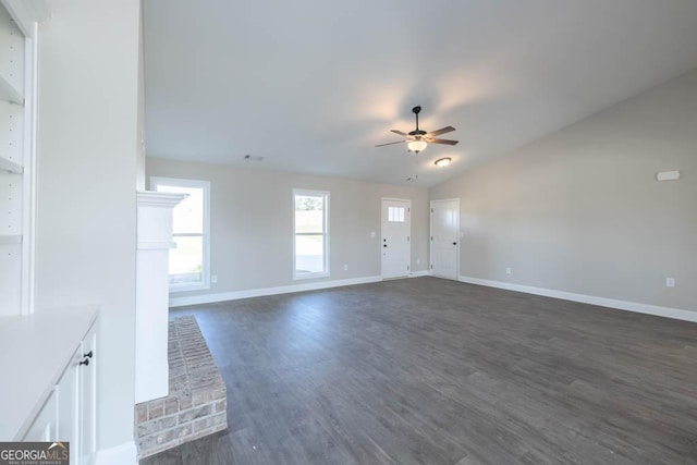 unfurnished living room featuring dark hardwood / wood-style flooring, vaulted ceiling, and ceiling fan