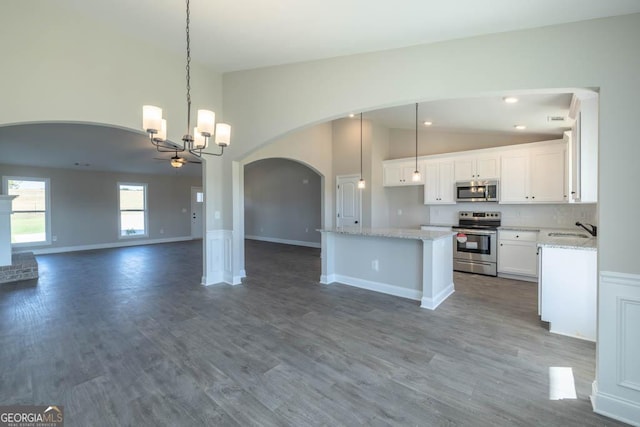 kitchen with pendant lighting, decorative backsplash, stainless steel appliances, and white cabinets