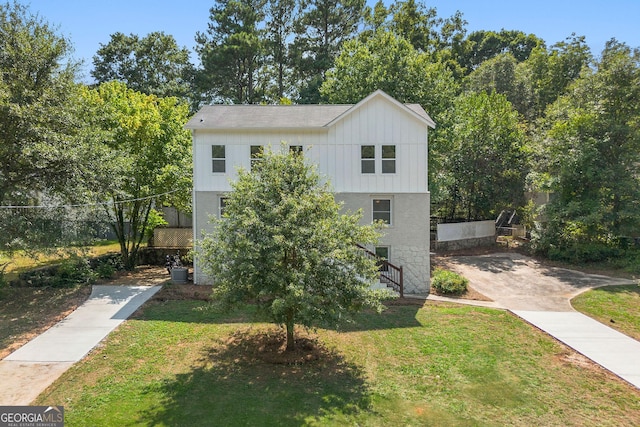 view of front of house with cooling unit and a front lawn