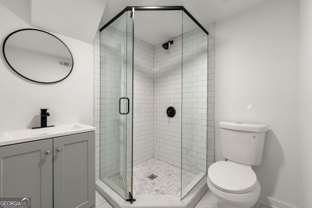 bathroom featuring vanity, an enclosed shower, and toilet