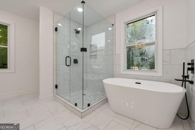 bathroom featuring independent shower and bath and tile walls