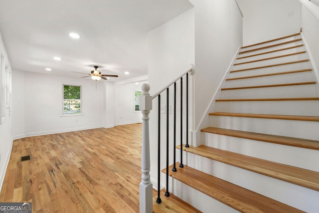 stairway featuring hardwood / wood-style flooring and ceiling fan