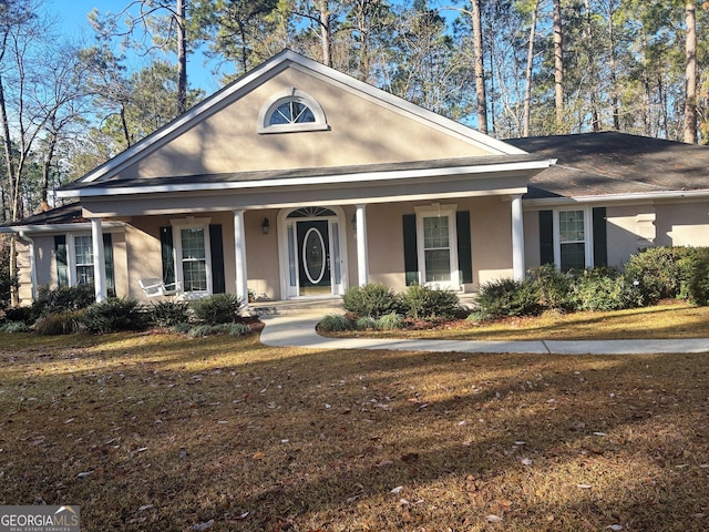 view of front of home with a front yard and covered porch