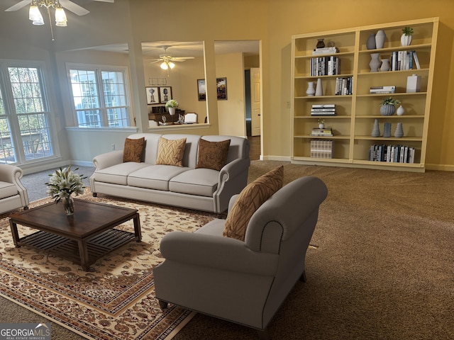 living area with a ceiling fan, carpet flooring, and baseboards