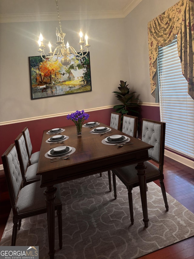 dining area with ornamental molding, wood finished floors, and an inviting chandelier