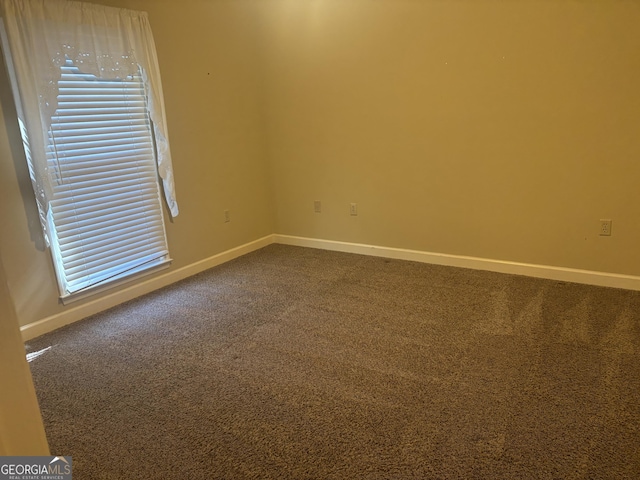 spare room with carpet and baseboards