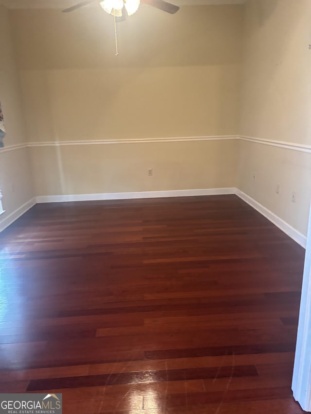 spare room with dark hardwood / wood-style floors and ceiling fan