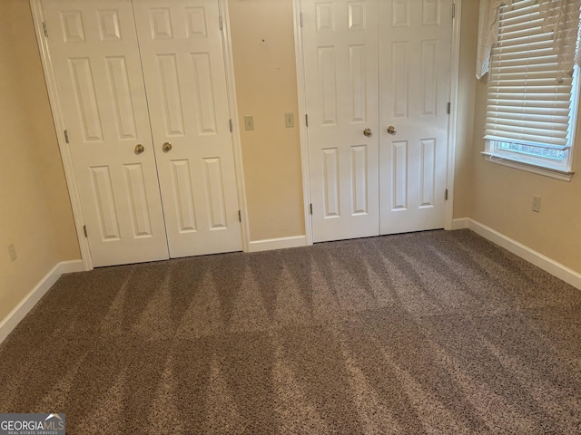 unfurnished bedroom featuring carpet flooring and baseboards