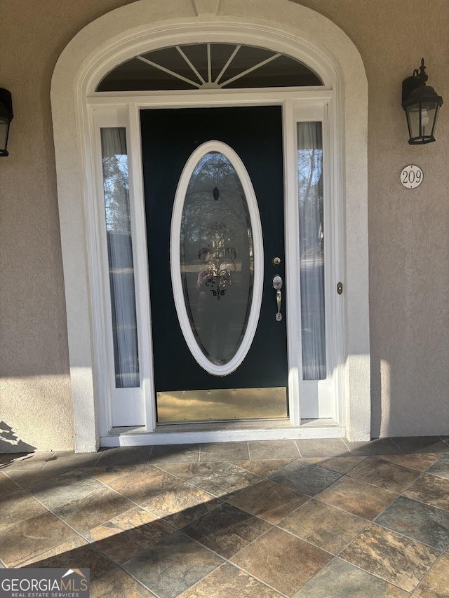 entrance to property featuring stucco siding