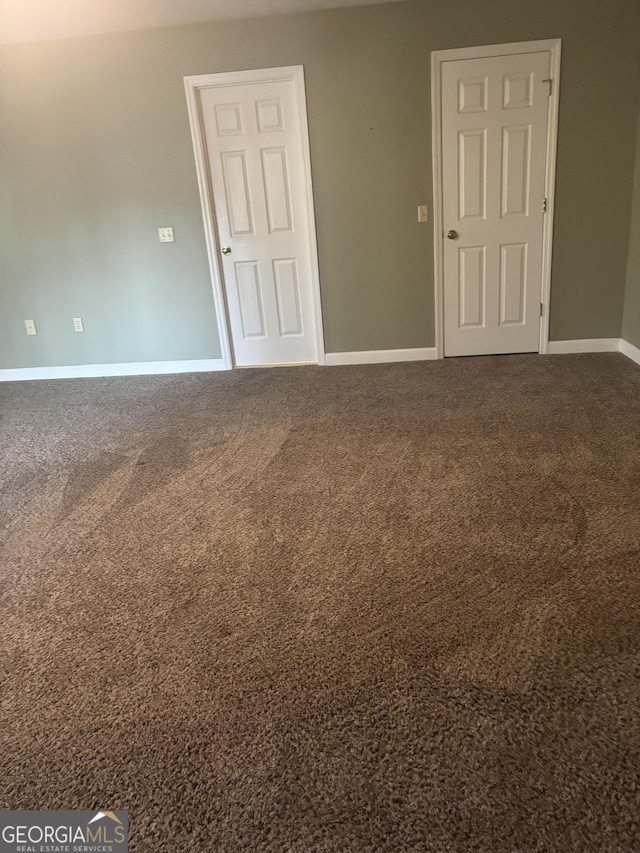 empty room featuring carpet and baseboards