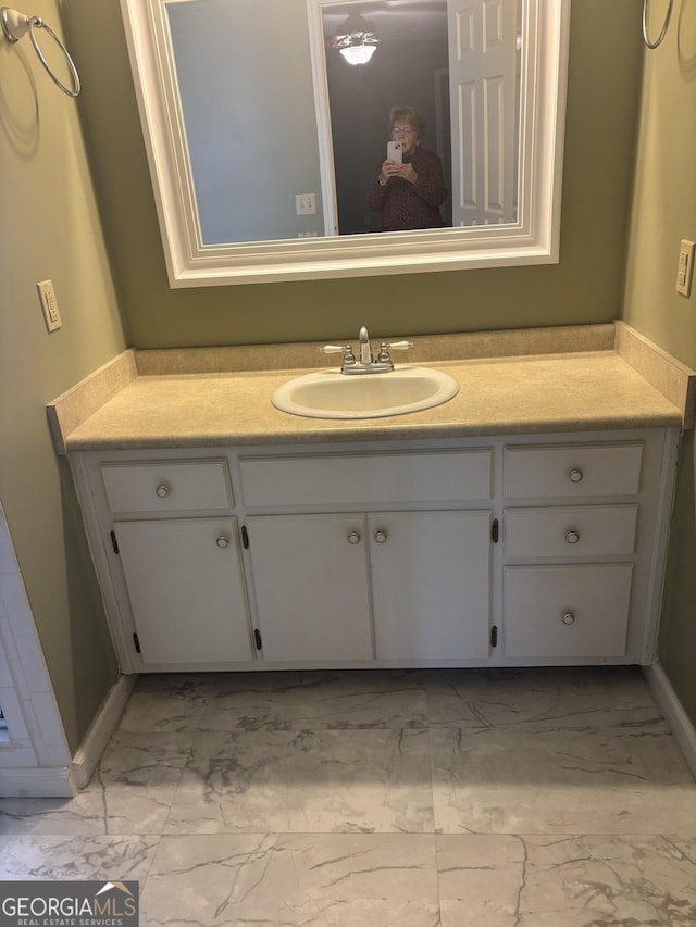 bathroom with marble finish floor and vanity