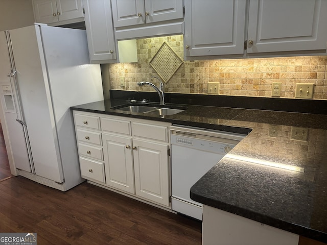 kitchen featuring white appliances, dark wood-type flooring, a sink, white cabinets, and dark countertops