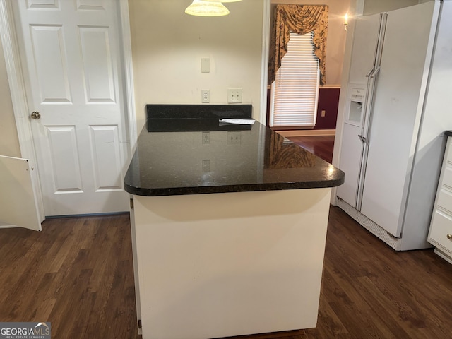 kitchen featuring white refrigerator with ice dispenser, white cabinets, and dark wood-type flooring