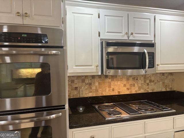 kitchen with white cabinetry, stainless steel appliances, and backsplash