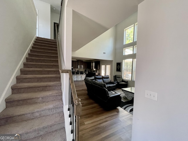 stairway featuring hardwood / wood-style floors and a high ceiling