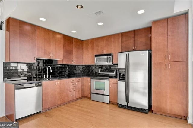 kitchen featuring appliances with stainless steel finishes, sink, and light hardwood / wood-style floors