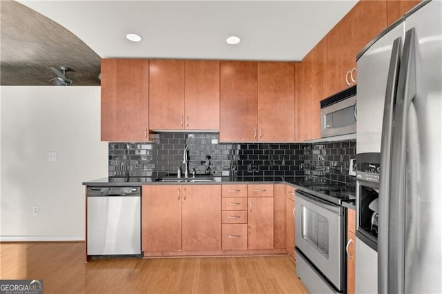 kitchen featuring appliances with stainless steel finishes, sink, and light wood-type flooring