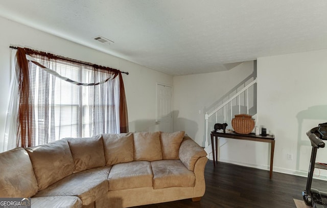 living room featuring dark hardwood / wood-style flooring and a textured ceiling