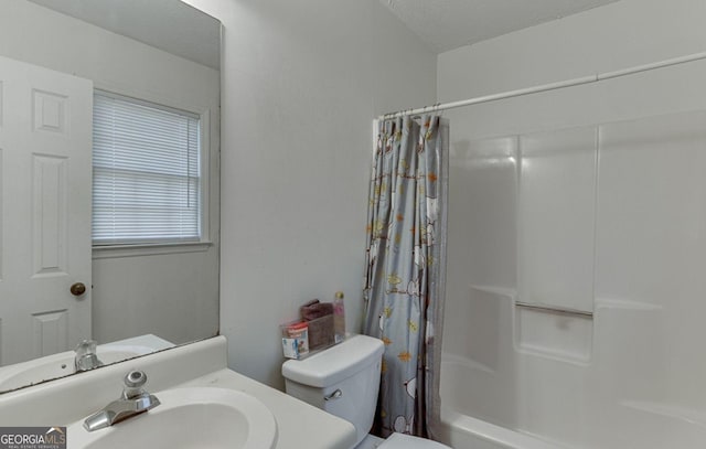 full bathroom with shower / bath combo with shower curtain, vanity, toilet, and a textured ceiling