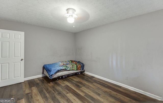 bedroom featuring a textured ceiling, dark hardwood / wood-style floors, and ceiling fan