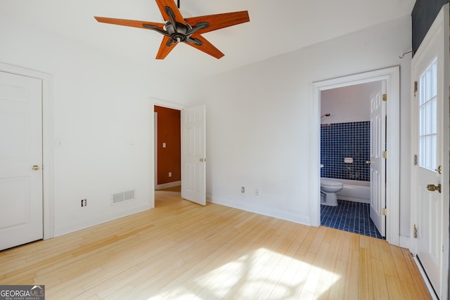 unfurnished bedroom with hardwood / wood-style flooring, ceiling fan, and ensuite bathroom