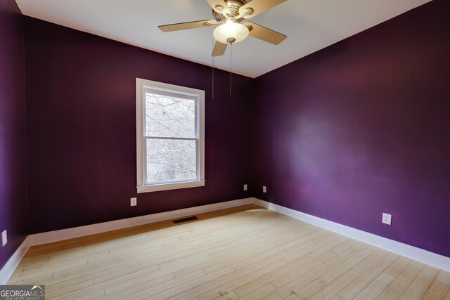 spare room with ceiling fan and light wood-type flooring