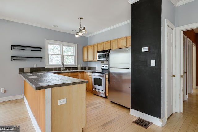 kitchen featuring sink, appliances with stainless steel finishes, hanging light fixtures, ornamental molding, and kitchen peninsula