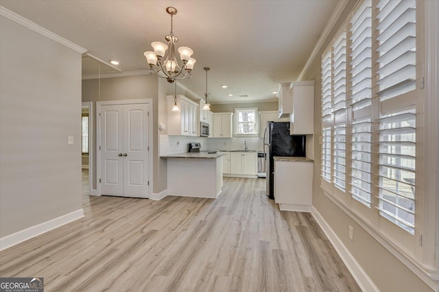 kitchen with crown molding, light hardwood / wood-style flooring, appliances with stainless steel finishes, white cabinetry, and hanging light fixtures