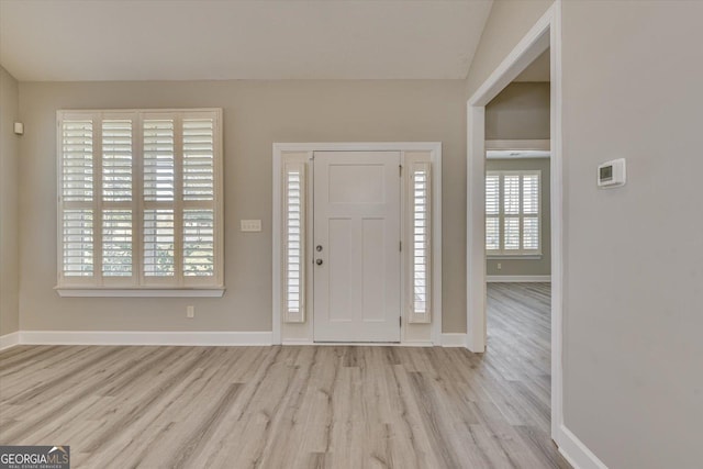 entrance foyer with lofted ceiling and light hardwood / wood-style flooring