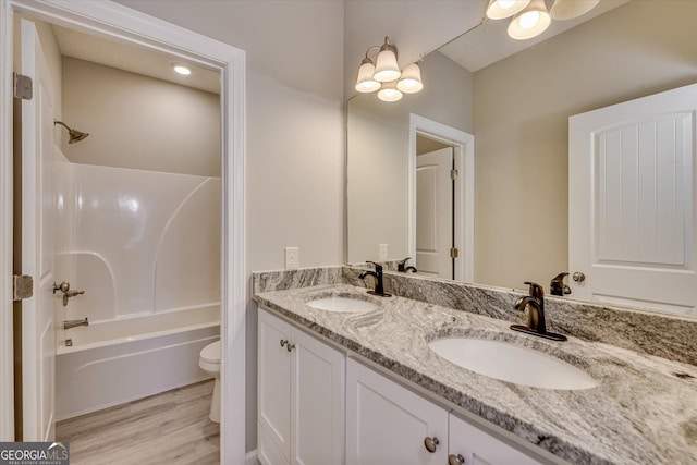 full bathroom with vanity, tub / shower combination, hardwood / wood-style floors, and toilet