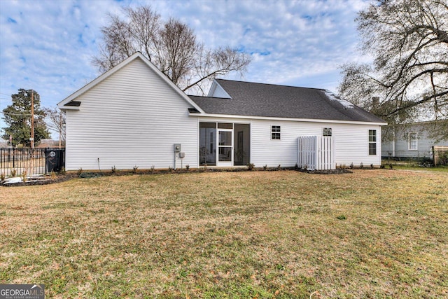 rear view of property featuring a lawn and a sunroom