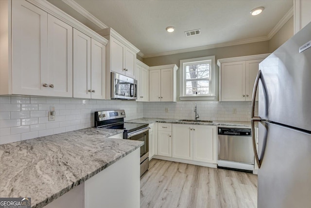 kitchen with appliances with stainless steel finishes, sink, and white cabinets