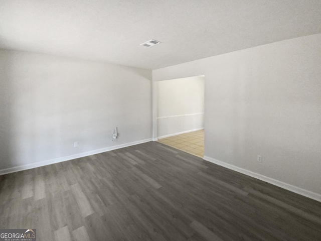 unfurnished room with dark hardwood / wood-style flooring